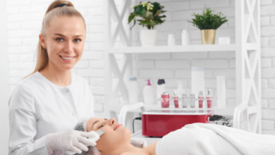 Estetista sorride mentre applica una crema su una cliente sdraiata sul lettino