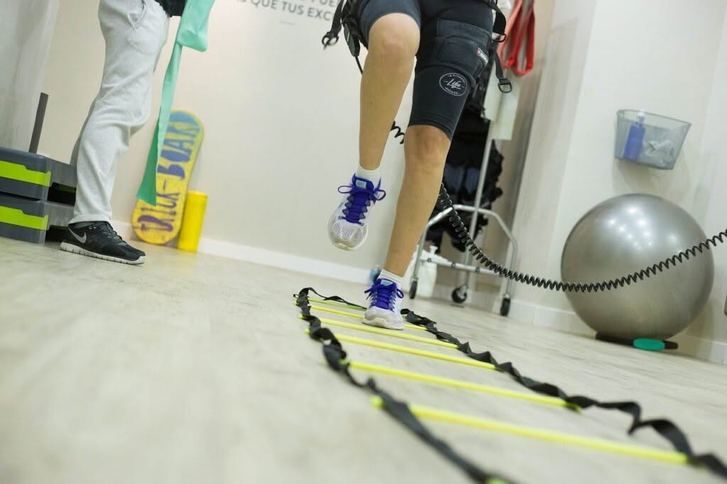 Paziente di fisioterapia corre mentre viene monitorato dal fisioterapista
