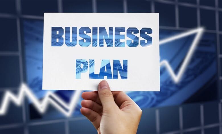 mano regge un cartello con scritto business plan