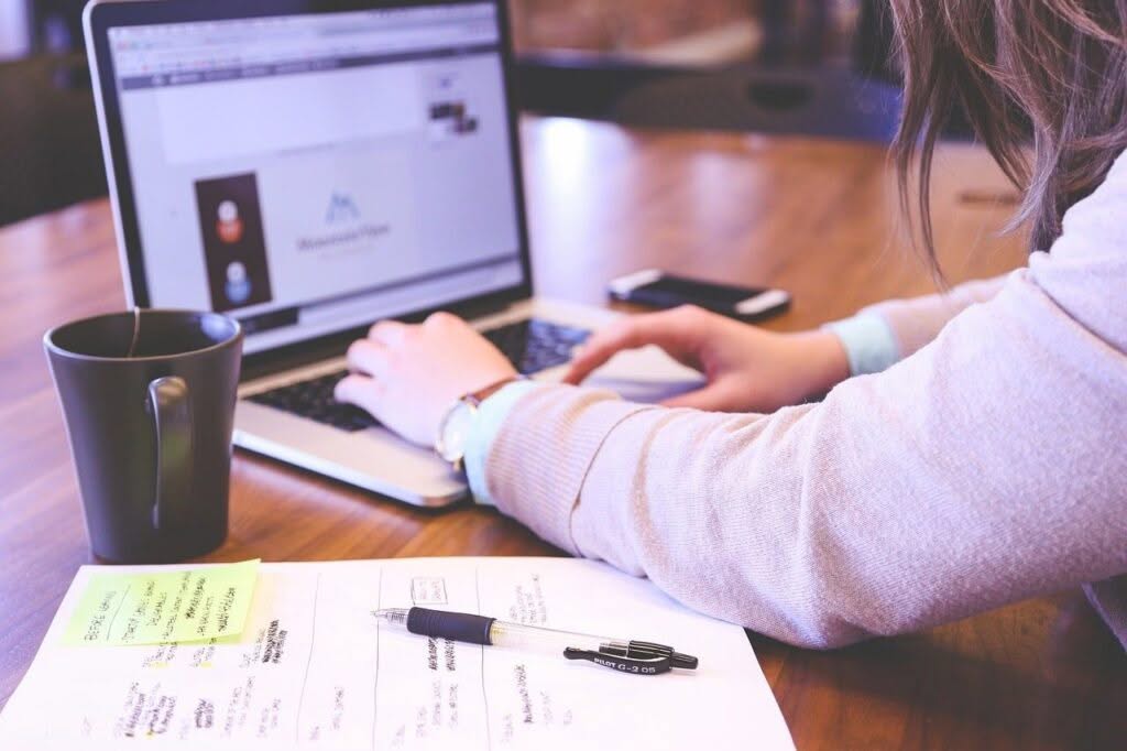 giovane donna scrive sulla tastiera di laptop