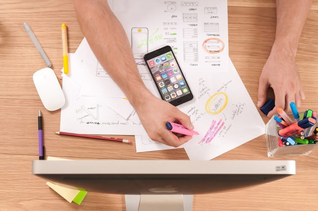 giovane disegna a mano il progetto di una app per dispositivi mobili