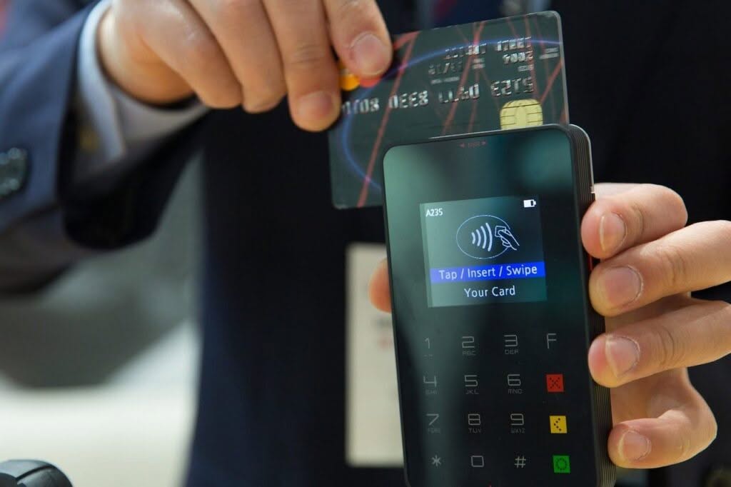 uomo passa carta di credito nel pos