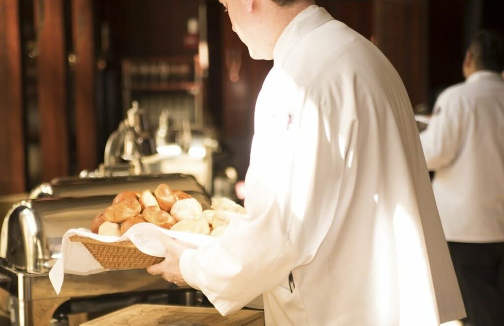cameriere con vassoio pieno di pane