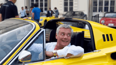 Uomo di mezza età di successo guida una ferrari gialla